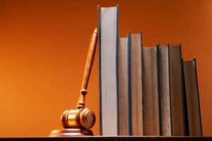 gavel hammer lean row books against orange background